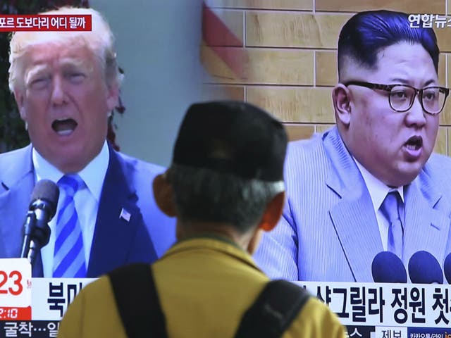 A man watches a TV screen showing file footage of Donald Trump Kim Jong-un in Seoul, South Korea