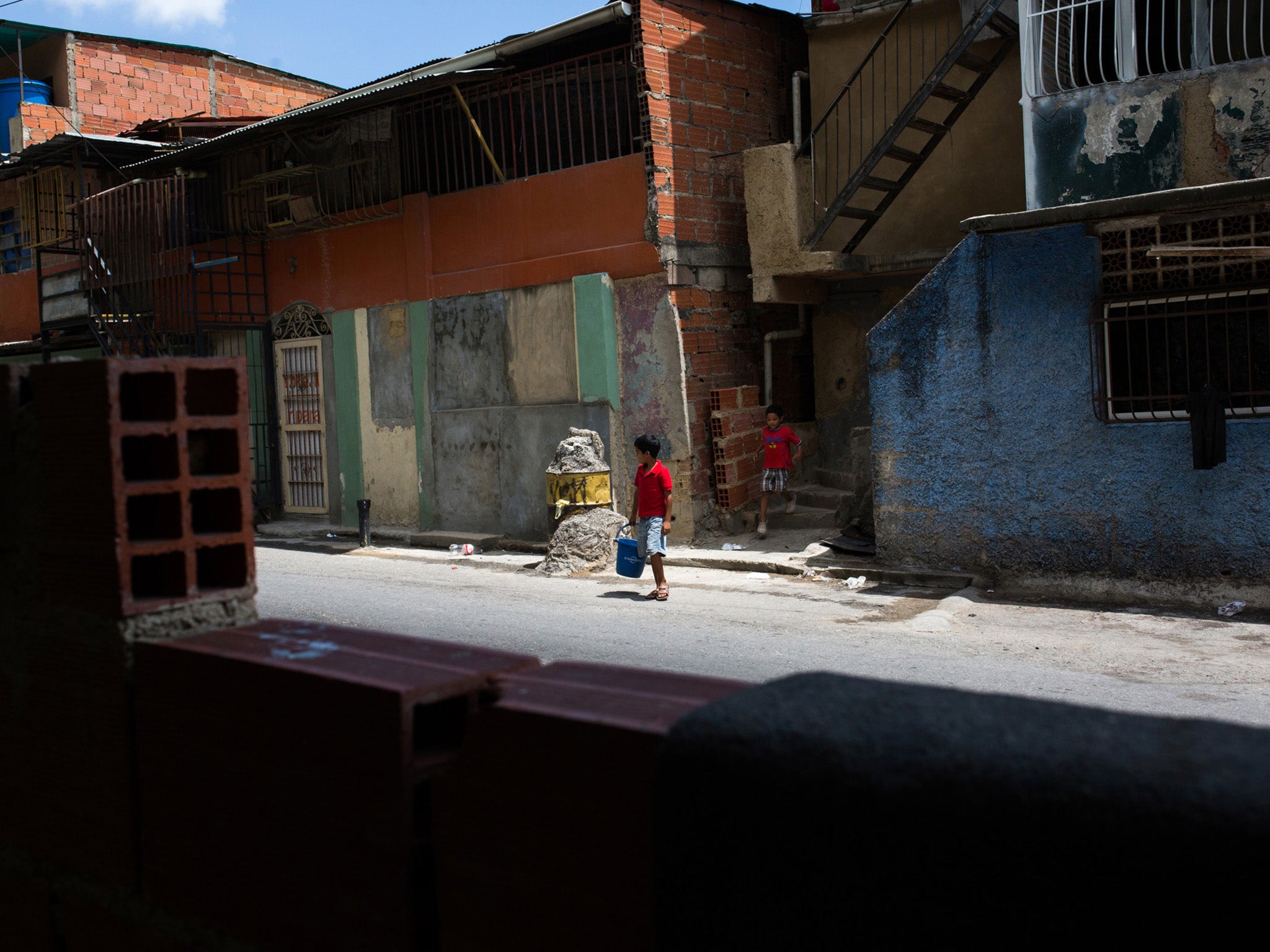 A child carries a plastic container on the outskirts of Caracas