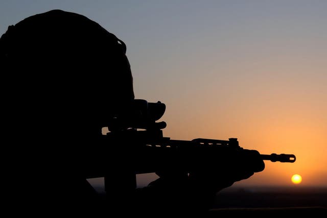The sun sets as a Royal Marine stands guard in the watchtower at Forward Operating Base Prise near Gereshk in Afghanistan, in 2007
