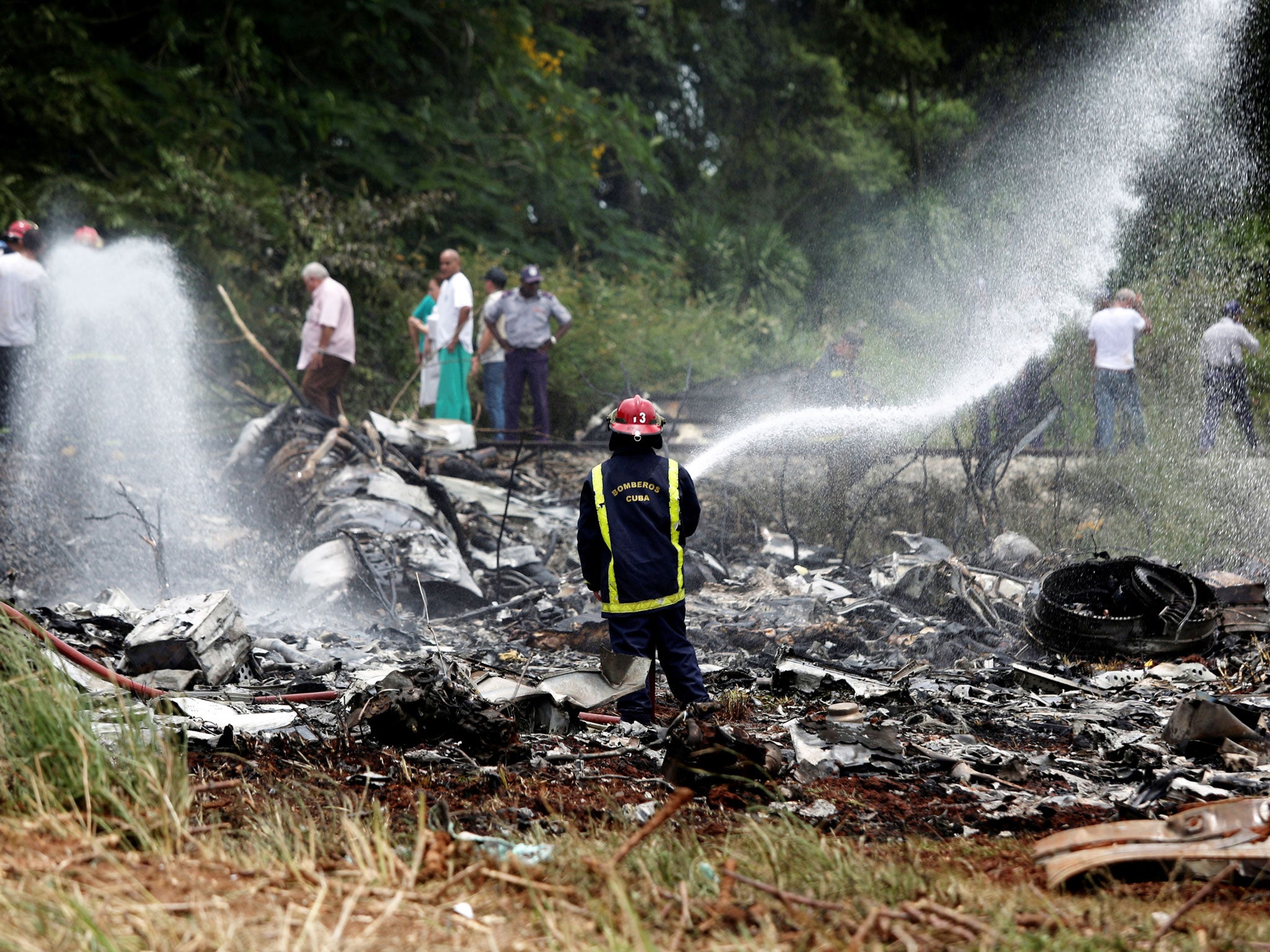 A firefighter works in the wreckage of a Boeing 737 plane that crashed in the agricultural area of Boyeros, around 12 miles south of Havana