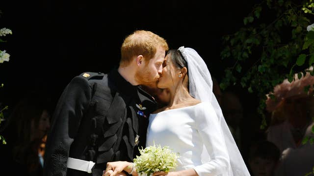 The Duke and Duchess of Sussex kiss on the steps of St George’s Chapel after their wedding