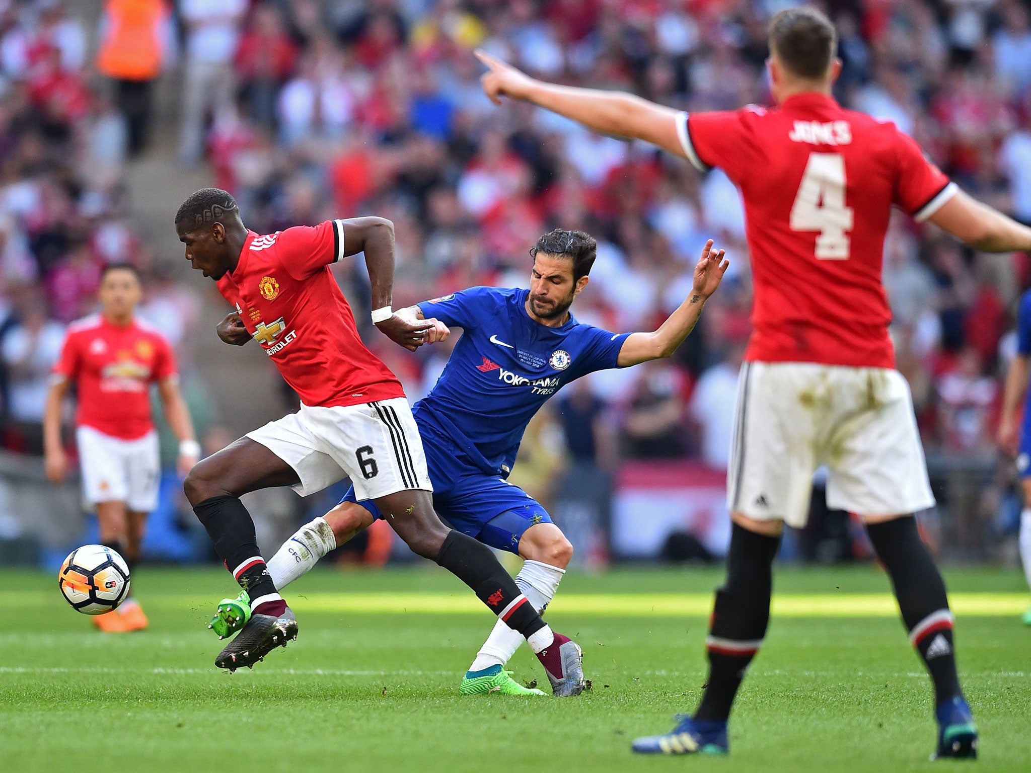 Paul Pogba attempts to get away from Cesc Fabregas