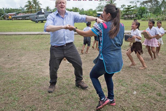 Johnson dances with teacher Adriana Pinedo during a visit to the village primary school in Santa Marta, on the bank of the Amazon near Iquitos in Peru