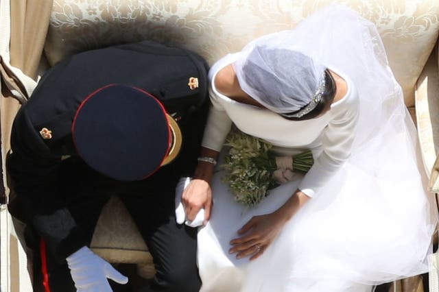 Prince Harry, Duke of Sussex and the Duchess of Sussex hold hands in the Ascot Landau Carriage