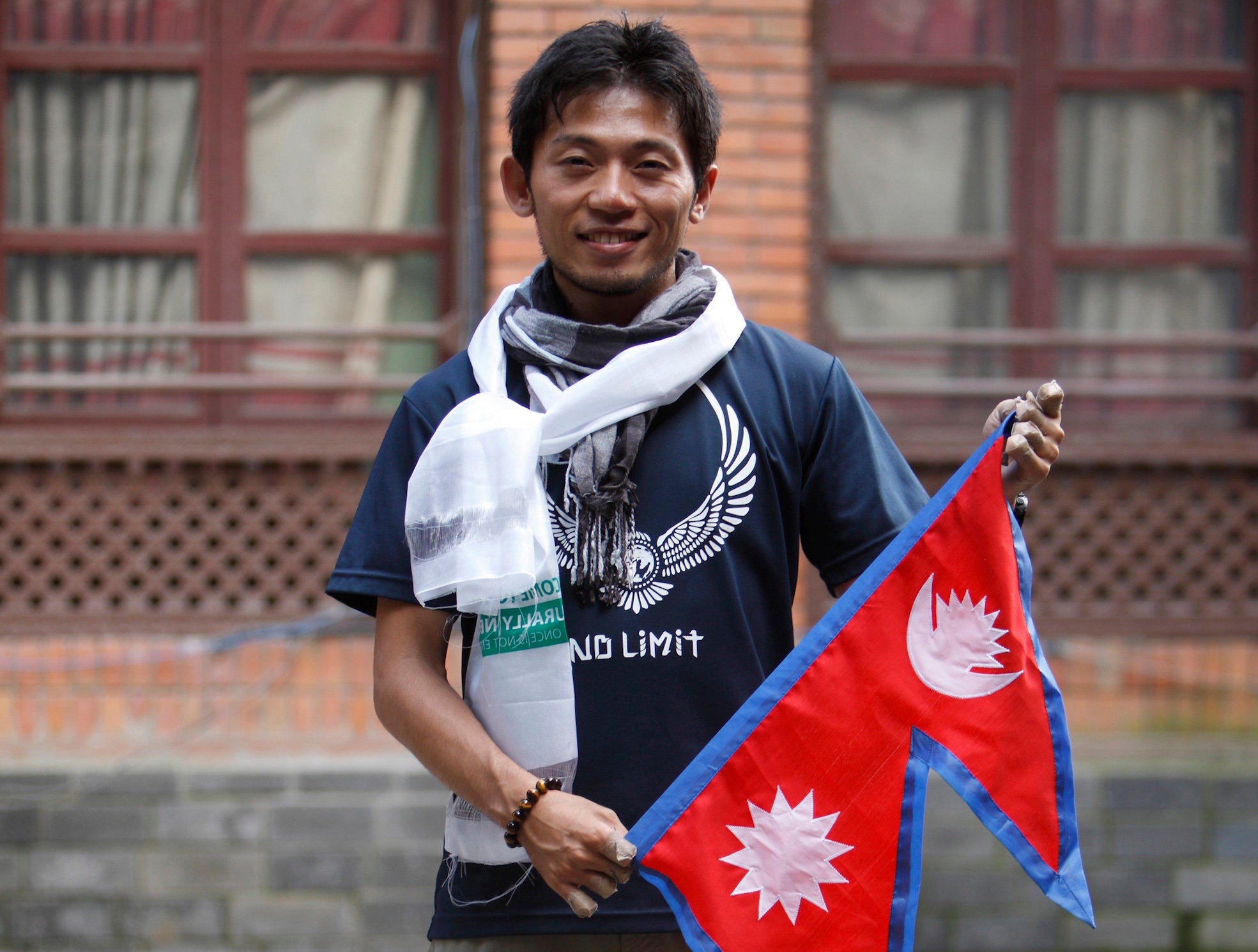 Japanese climber Nobukazu Kuriki poses with a Nepalese flag in 2015