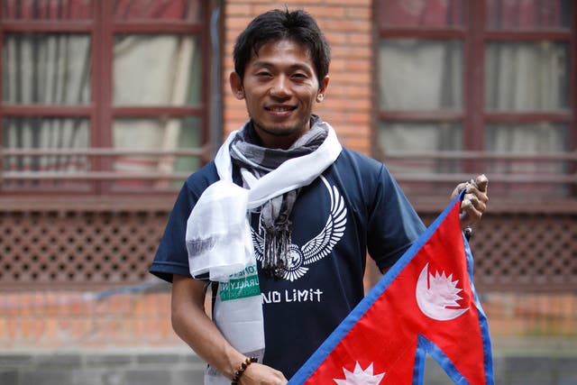 Japanese climber Nobukazu Kuriki poses with a Nepalese flag in 2015