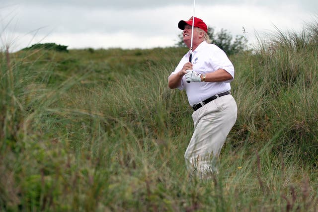 Donald Trump hacks his way out of the rough on his Scottish golf course.