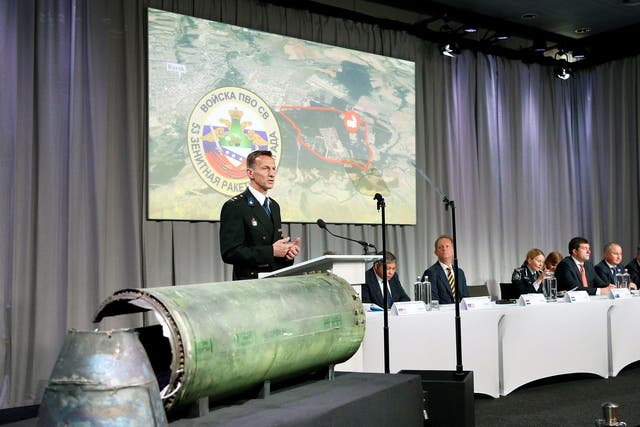 Wilbert Paulissen, head of the Dutch National Crime Squad, stands next to a damaged missile as he presents interim results in the ongoing investigation into the shooting down of MH17