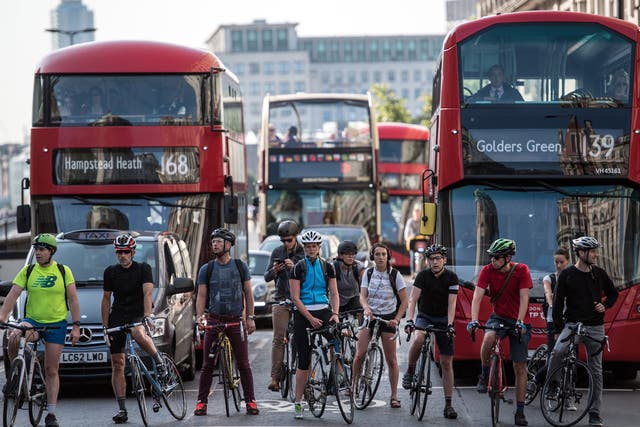 Cyclists wait at traffic lights in London on 25 August 2017