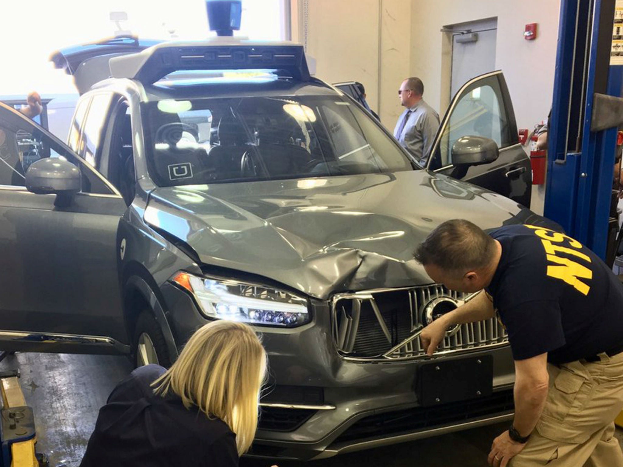 National Transportation Safety Board investigators examine the self-driving Uber vehicle that struck and killed a woman in Arizona