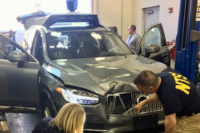 National Transportation Safety Board investigators examine the self-driving Uber vehicle that struck and killed a woman in Arizona