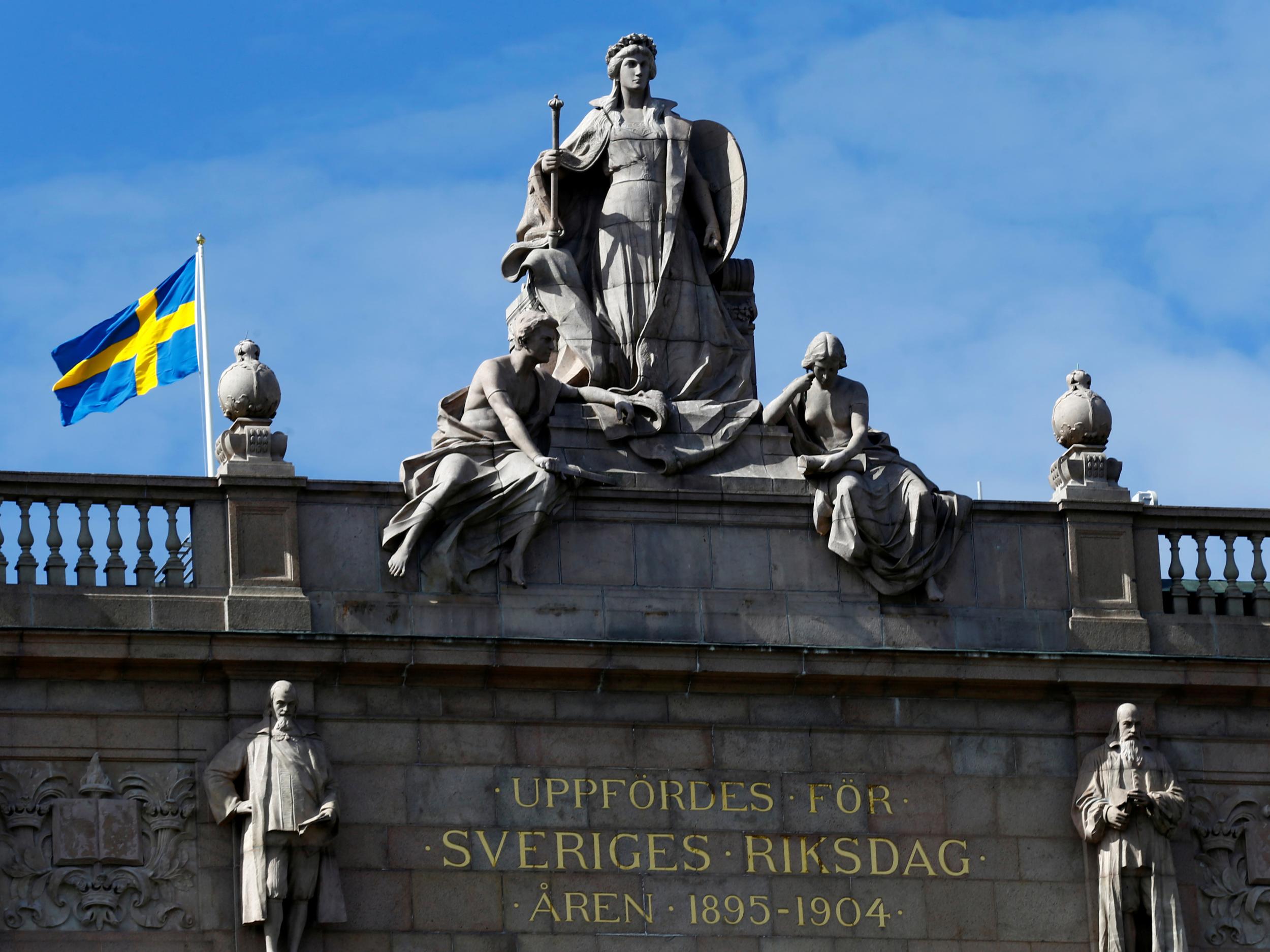 The Swedish flag flutters next to the country's Parliament, where politicians have voted to introduce new rape laws
