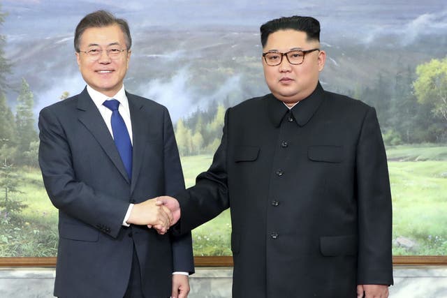 North Korean leader Kim Jong Un, right, and South Korean President Moon Jae-in, left, shake hands before their meeting at the northern side of the Panmunjom