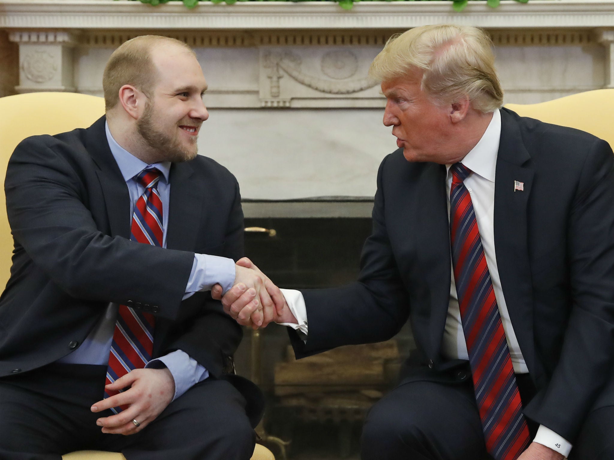 President Donald Trump shakes hands with Joshua Holt at the White House