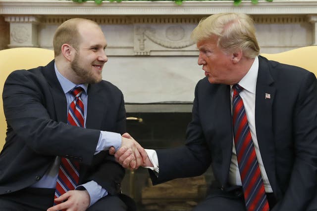 President Donald Trump shakes hands with Joshua Holt at the White House