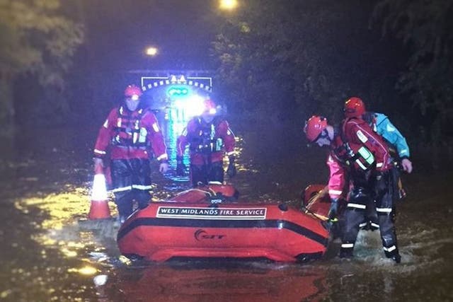 Members of the Technical Rescue Unit of West Midlands Fire Service with a boat in Birmingham after more than a month's rainfall deluged parts of Birmingham in just one hour