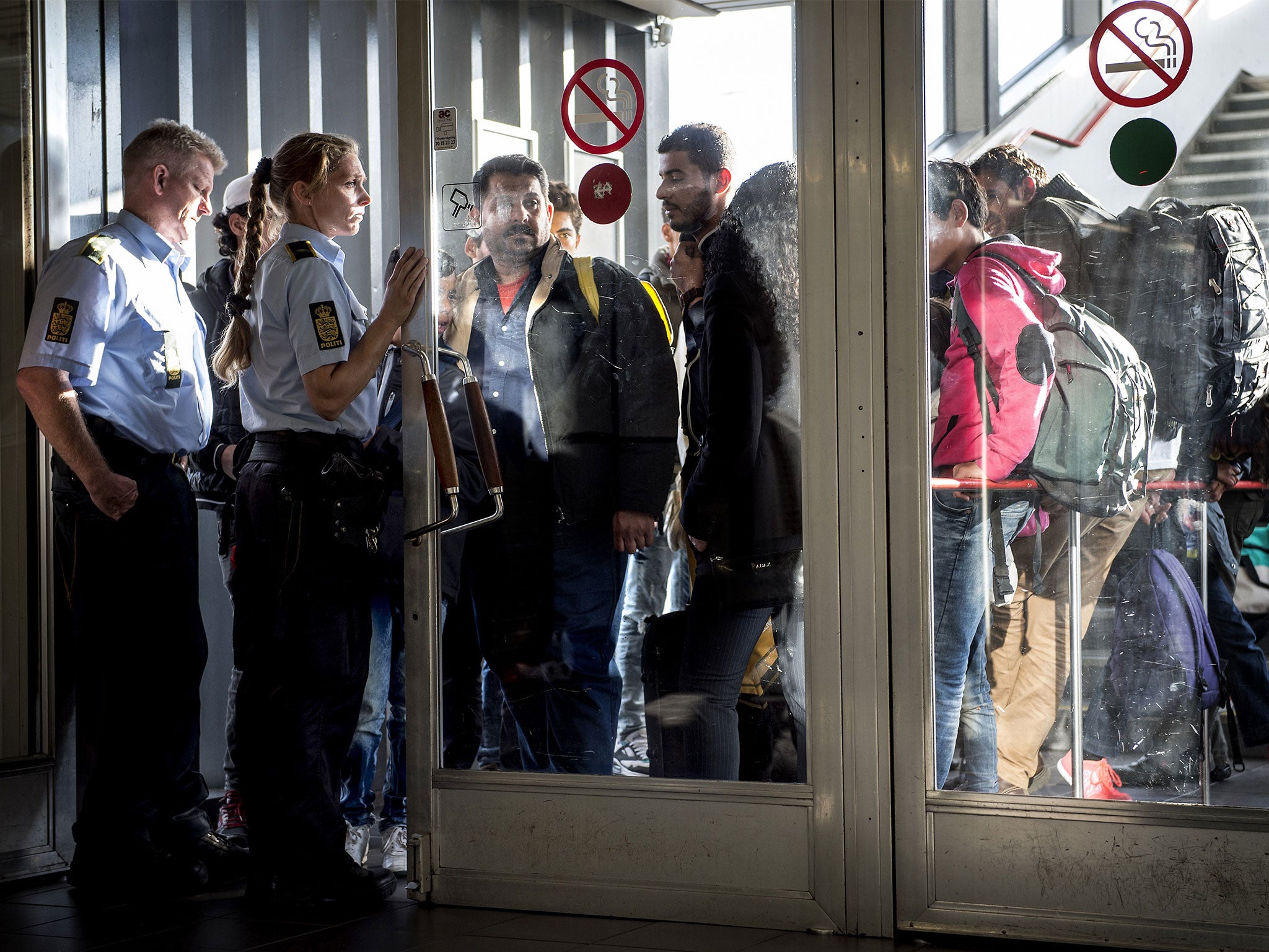 Police guide a group of migrants as they arrive in Rodby, Denmark