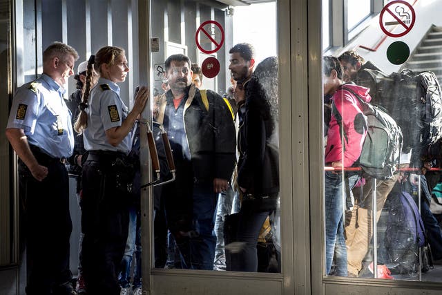 Police guide a group of migrants as they arrive in Rodby, Denmark