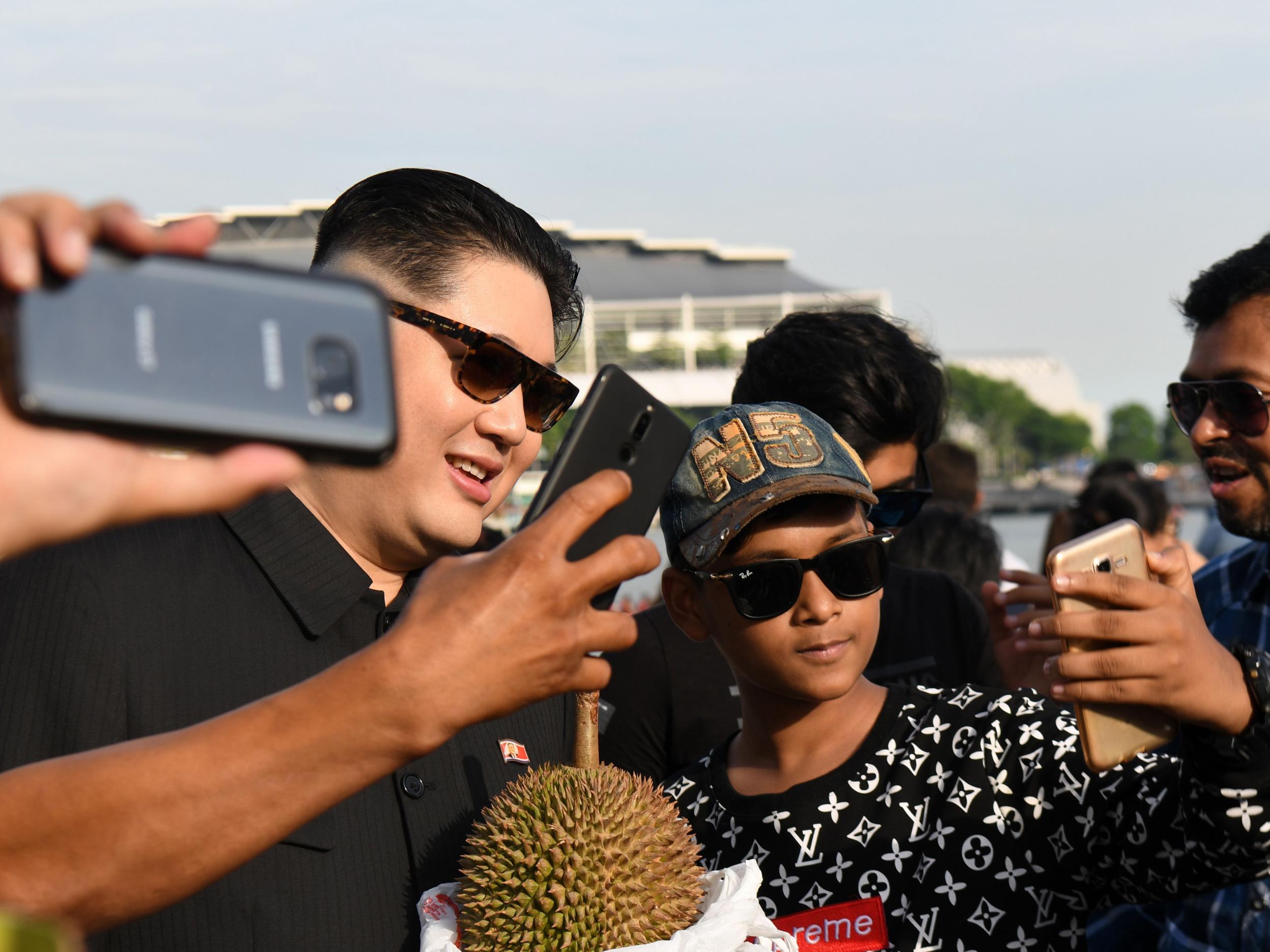 A Kim Jong-un impersonator takes selfies in Singapore’s Merlion Park. The world is gearing up for the planned summit between Mr Kim and Donald Trump as officials from both sides criss-cross the globe