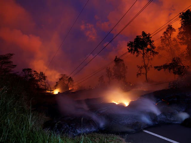 Volcanic gases rise from the Kilauea lava flow that crossed a road on Big Island.