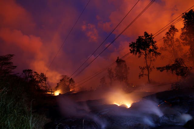 Volcanic gases rise from the Kilauea lava flow that crossed a road on Big Island.
