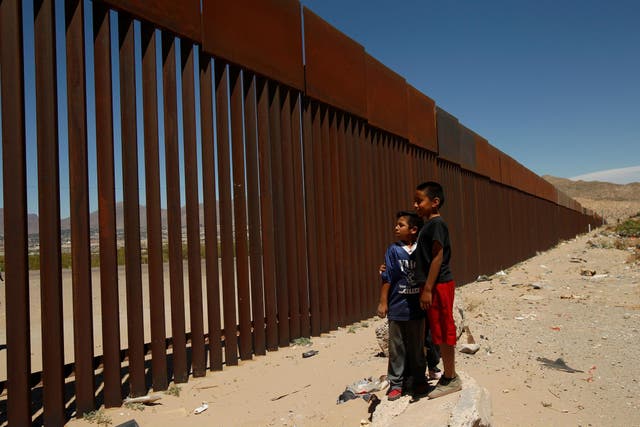 Children stand by a new section of the border wall on the U.S.-Mexico border in this picture taken from Anapra neighborhood in Ciudad Juarez, Mexico May 3, 2018. 