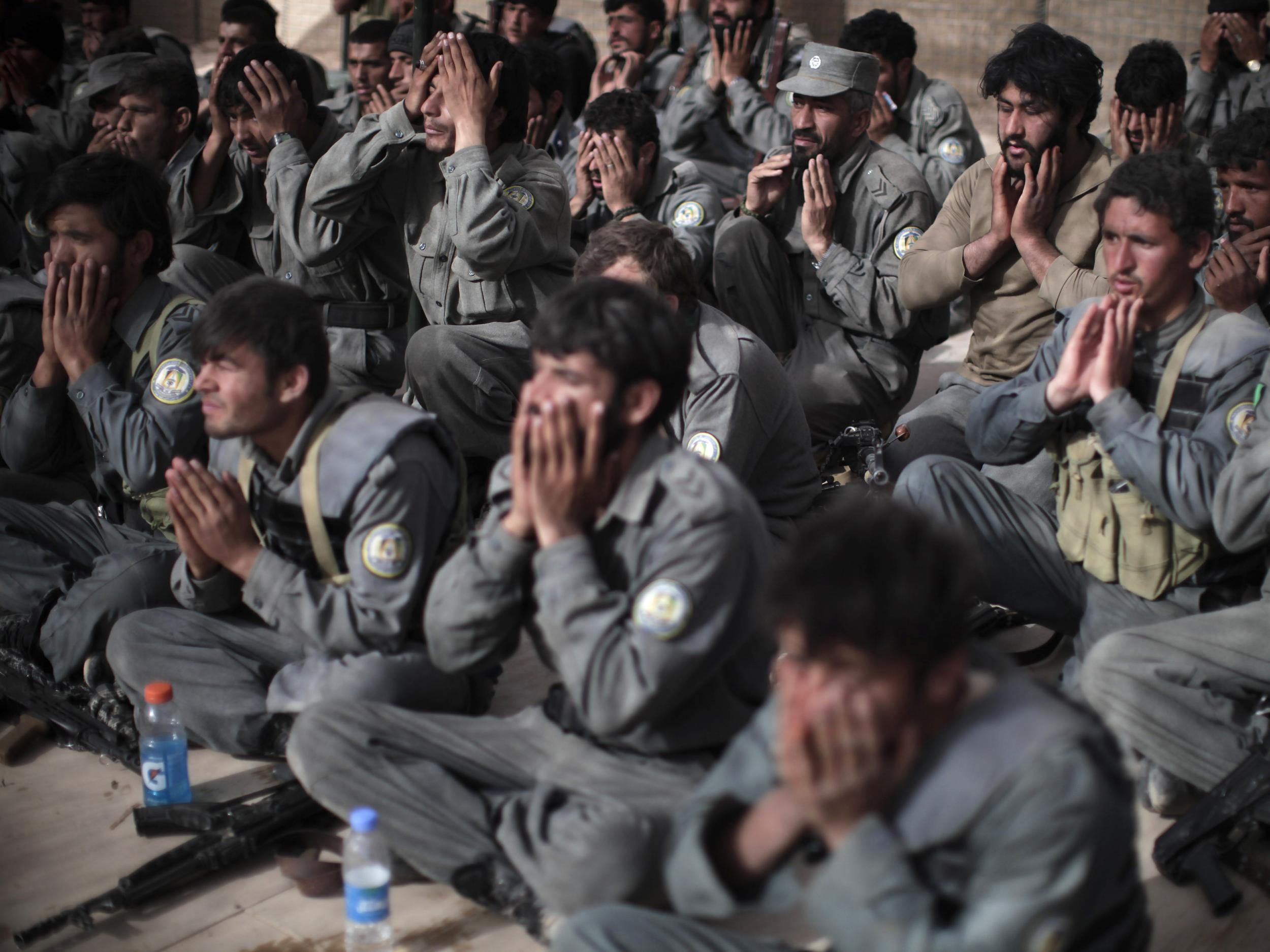 Afghan policemen pray at the US base in Marja (Getty)