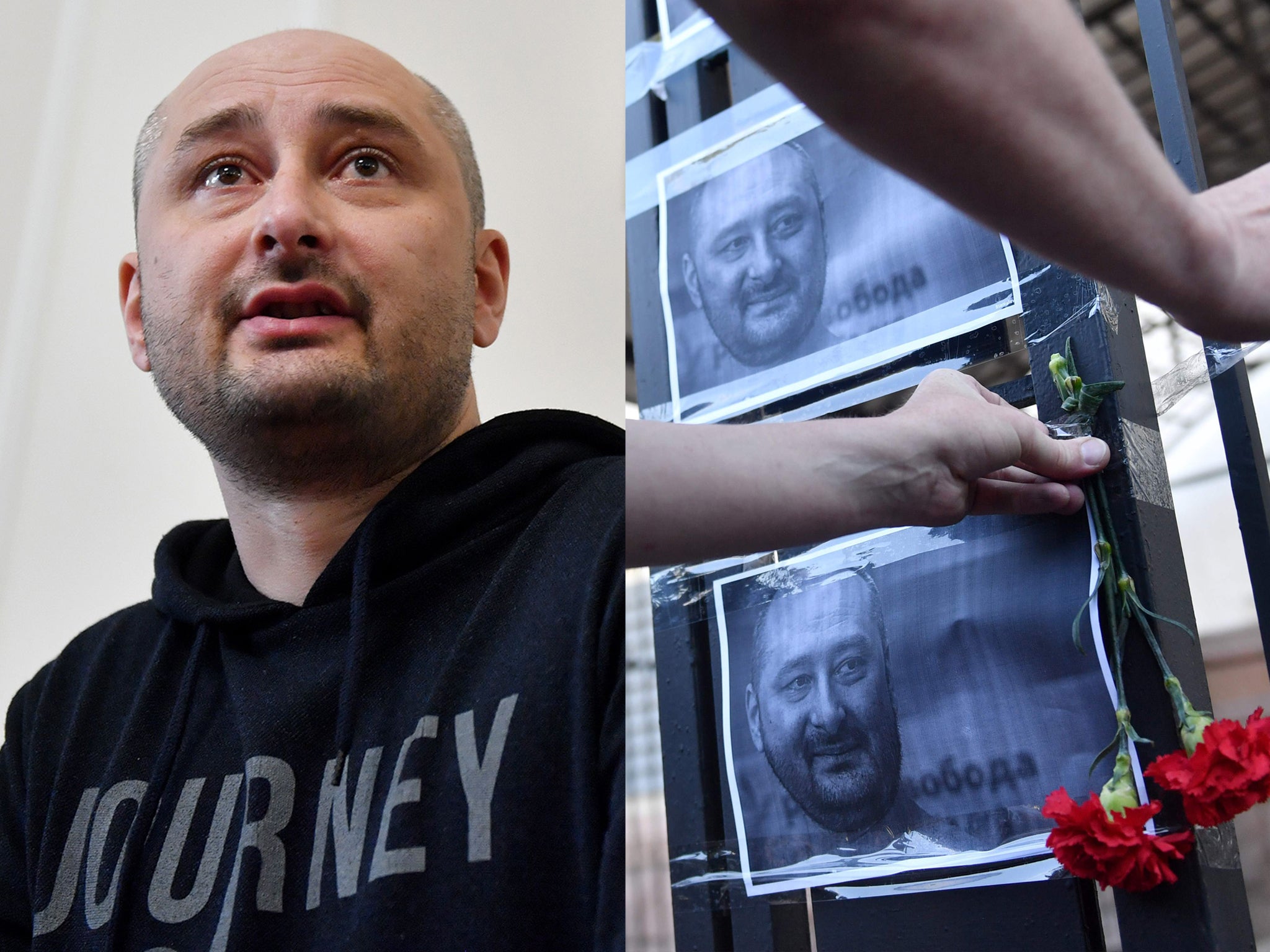 An activist hangs portraits of Mr Babchenko to the fence of Russian embassy in Kiev