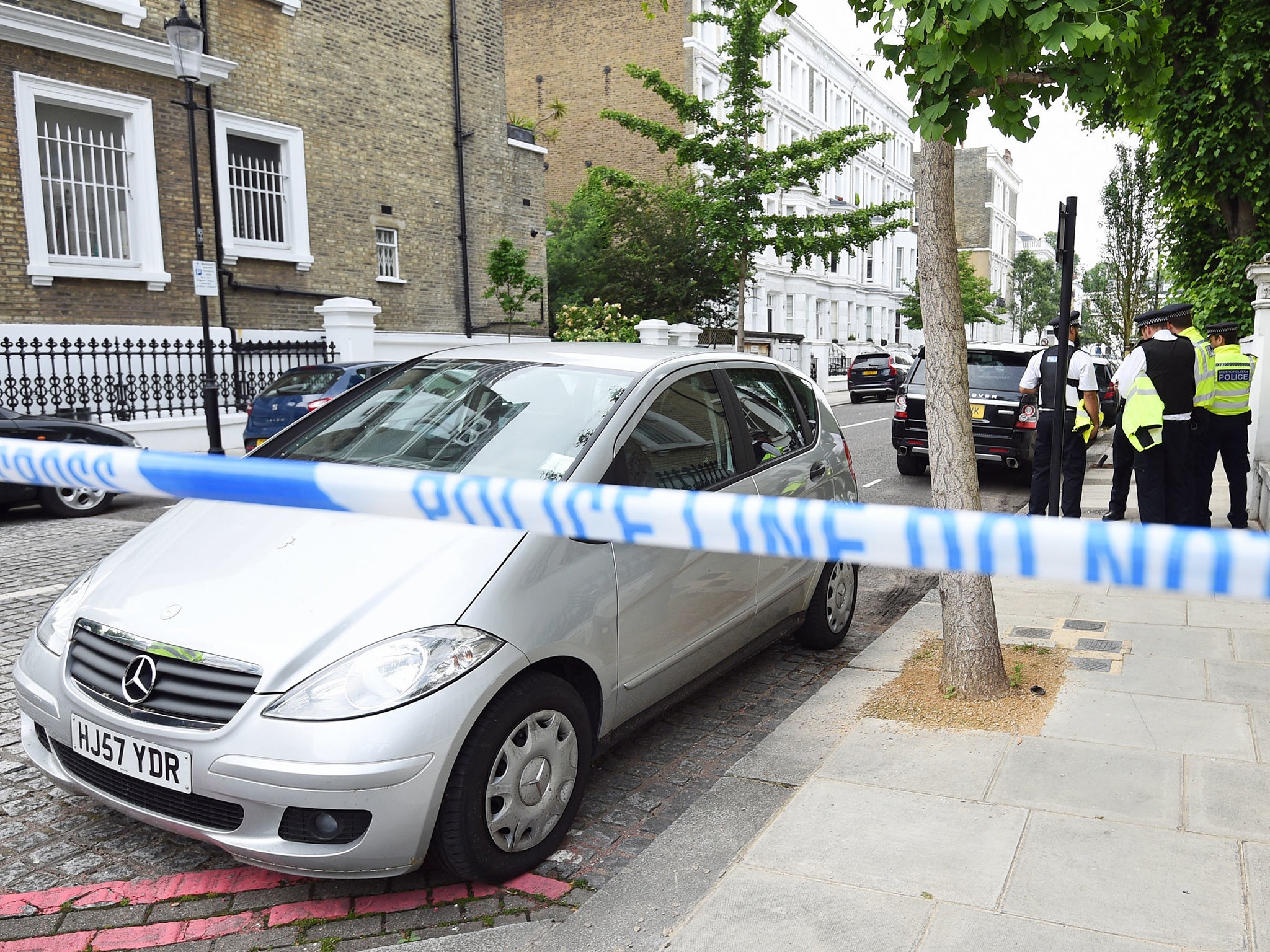 Police officers at the murder scene in Kensington, west London, where a man was stabbed to death.