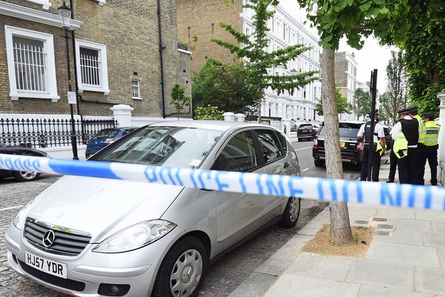 Police officers at the murder scene in Kensington, west London, where a man was stabbed to death.