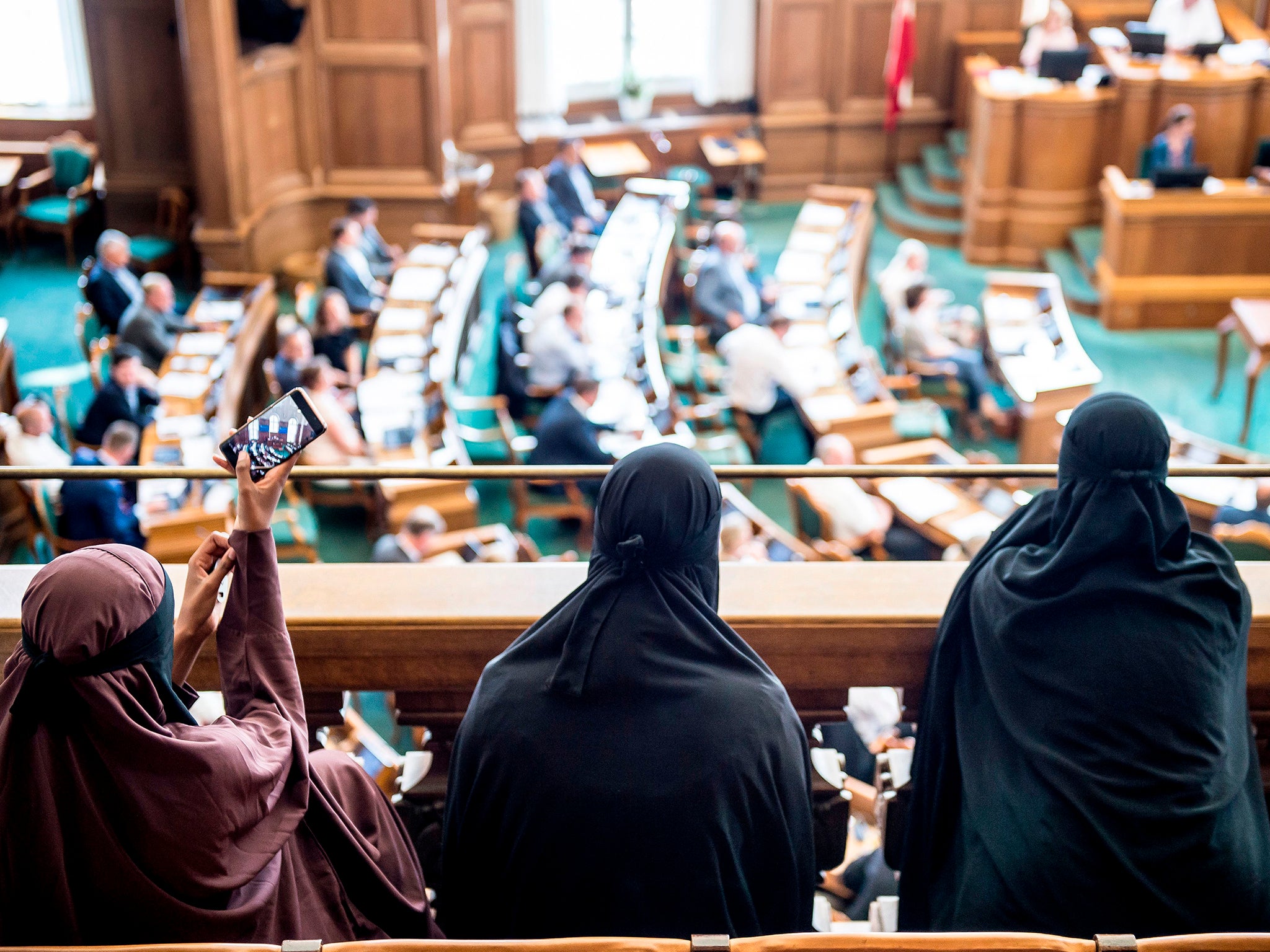 Women wearing niqab sit in the audience at the Danish Parliament in Copenhagen