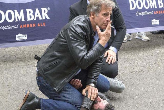 The leather jacket-wearing man take a puff on his cigarette while making a citizen's arrest