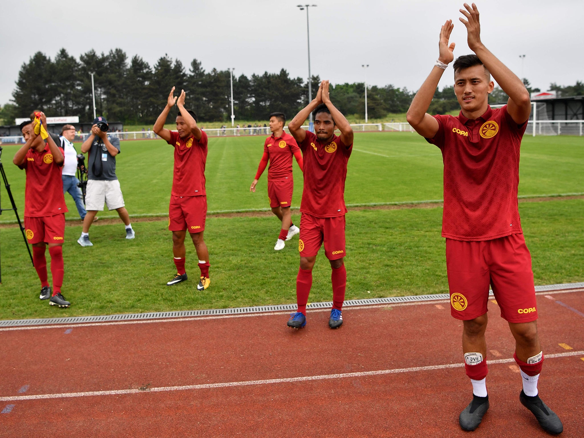 Tibet players applaud after the full-time whistle