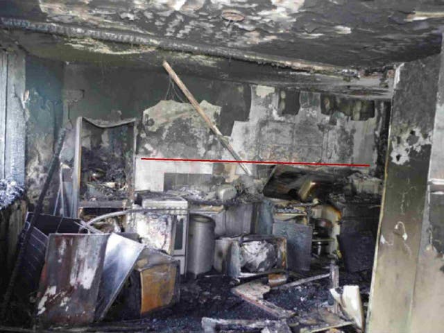 The kitchen in flat 16 where the fire started, with a red line showing 'the delineation of the area of damage', from an expert report