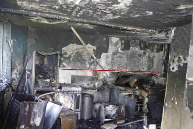 The kitchen in flat 16 where the fire started, with a red line showing 'the delineation of the area of damage', from an expert report