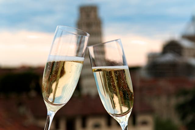 <p>Two glasses of prosecco in front of the Leaning Tower of Pisa </p>