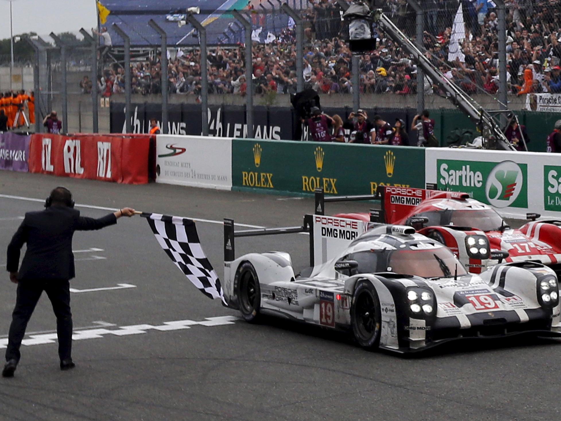 Porsche 919 Hybrid number 19 driver Nico Hulkenberg crosses the finish line to win the Le Mans 24-hour sports car race on 14 June 2015