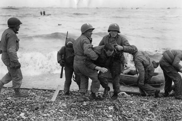 American troops helping injured friends after their dinghy was hit by enemy fire during the D-Day landings