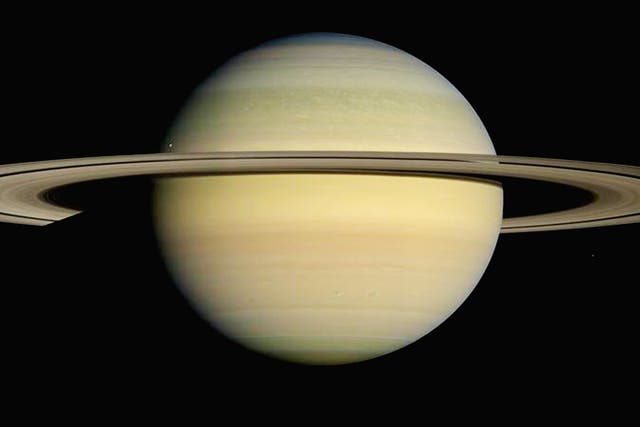 Saturn is girdled by brilliant appendages that would stretch almost all the way from the Earth to the Moon