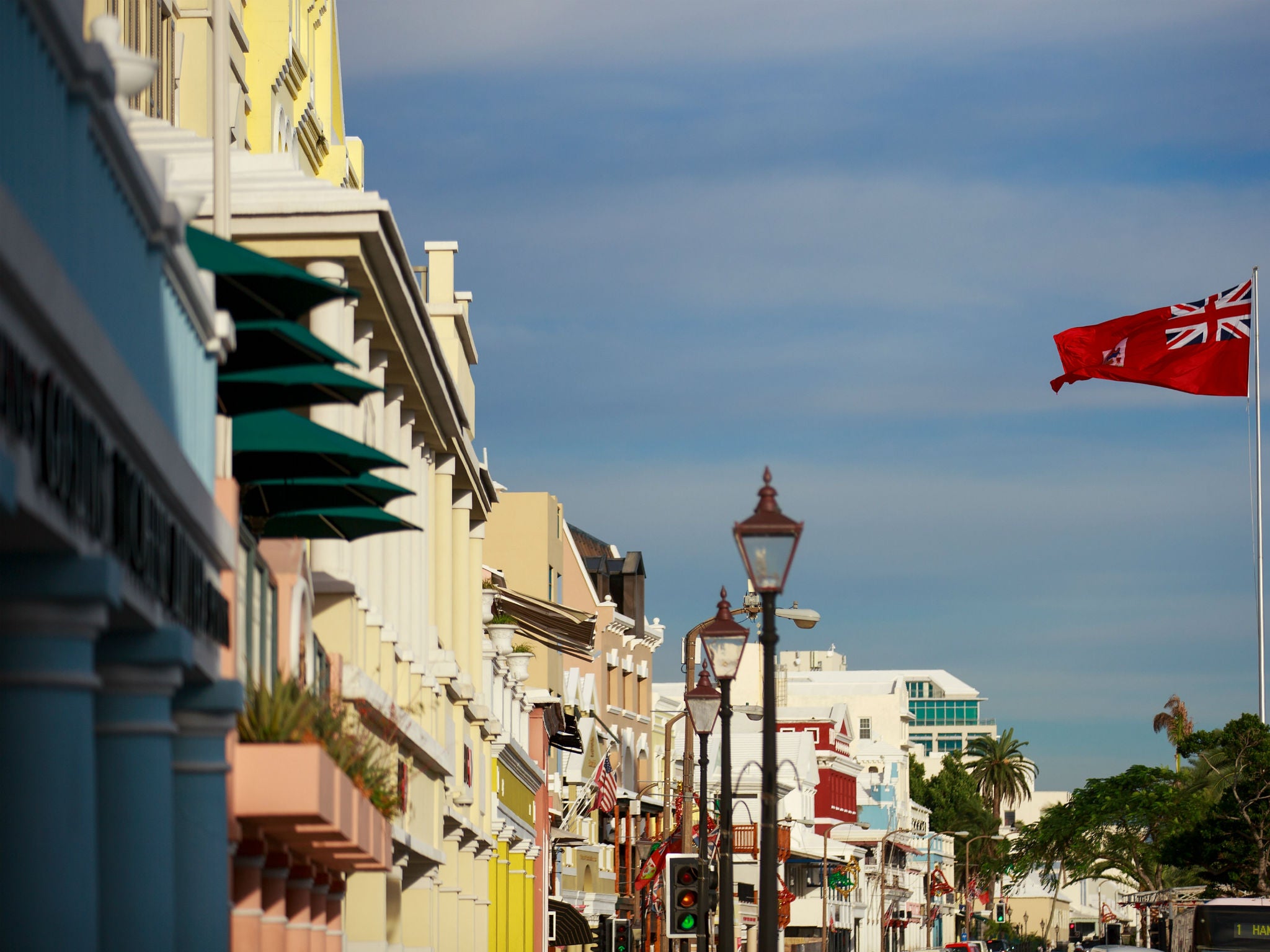 The flag of Bermuda flies along the commercial and retail district on Front Street, in Hamilton, Bermuda