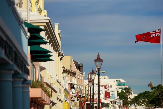 The flag of Bermuda flies along the commercial and retail district on Front Street, in Hamilton, Bermuda