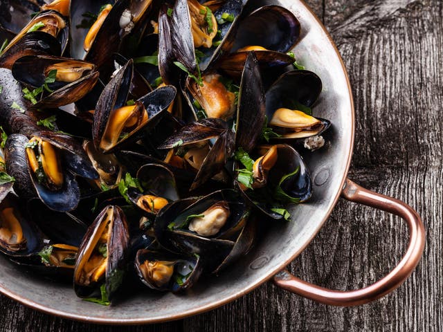 Boiled mussels in copper cooking dish