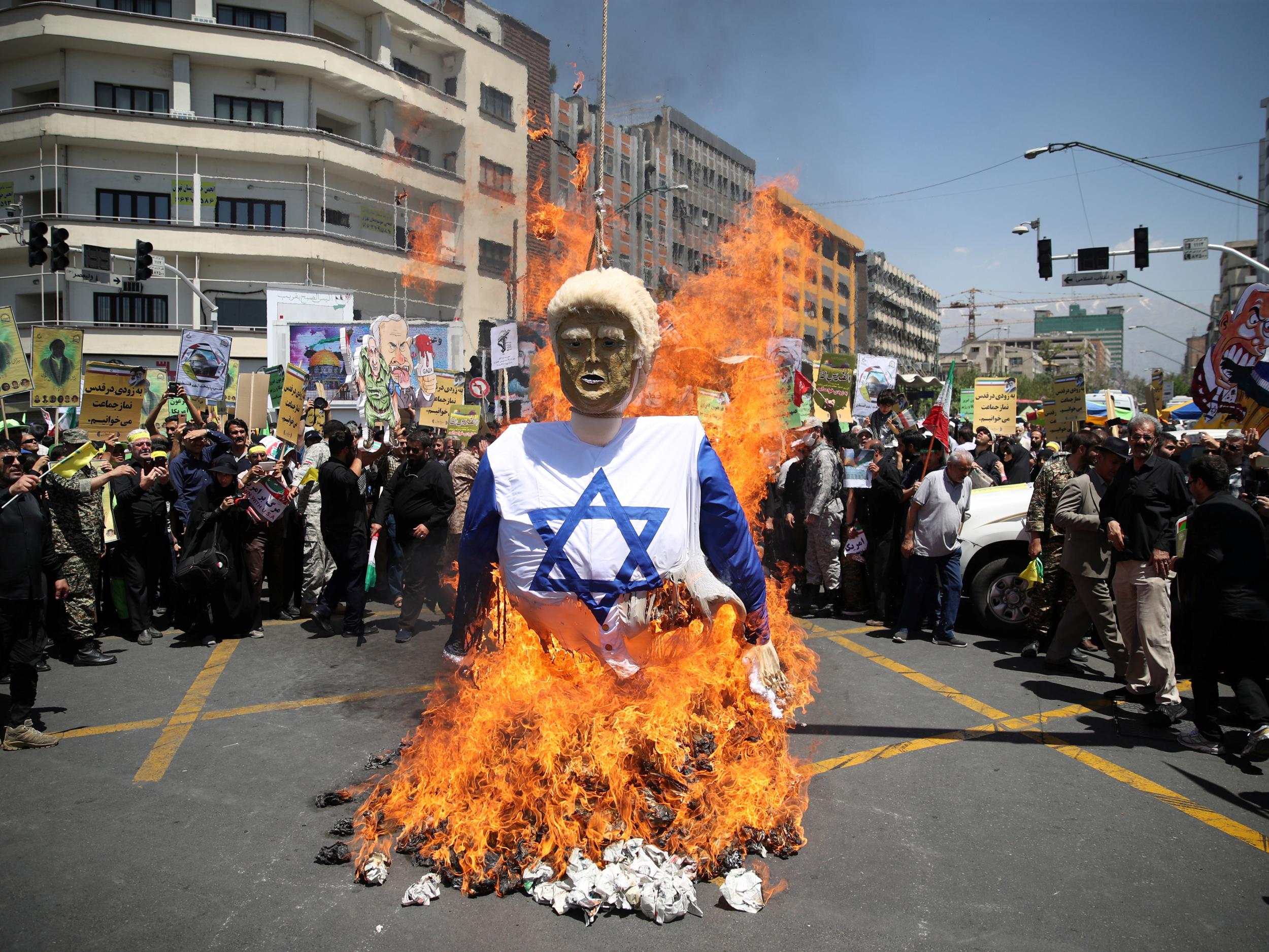 Iranians burn an effigy in the likeness of US President Donald Trump during a protest marking the annual Quds Day on the last Friday of the holy month of Ramadan in Tehran, Iran