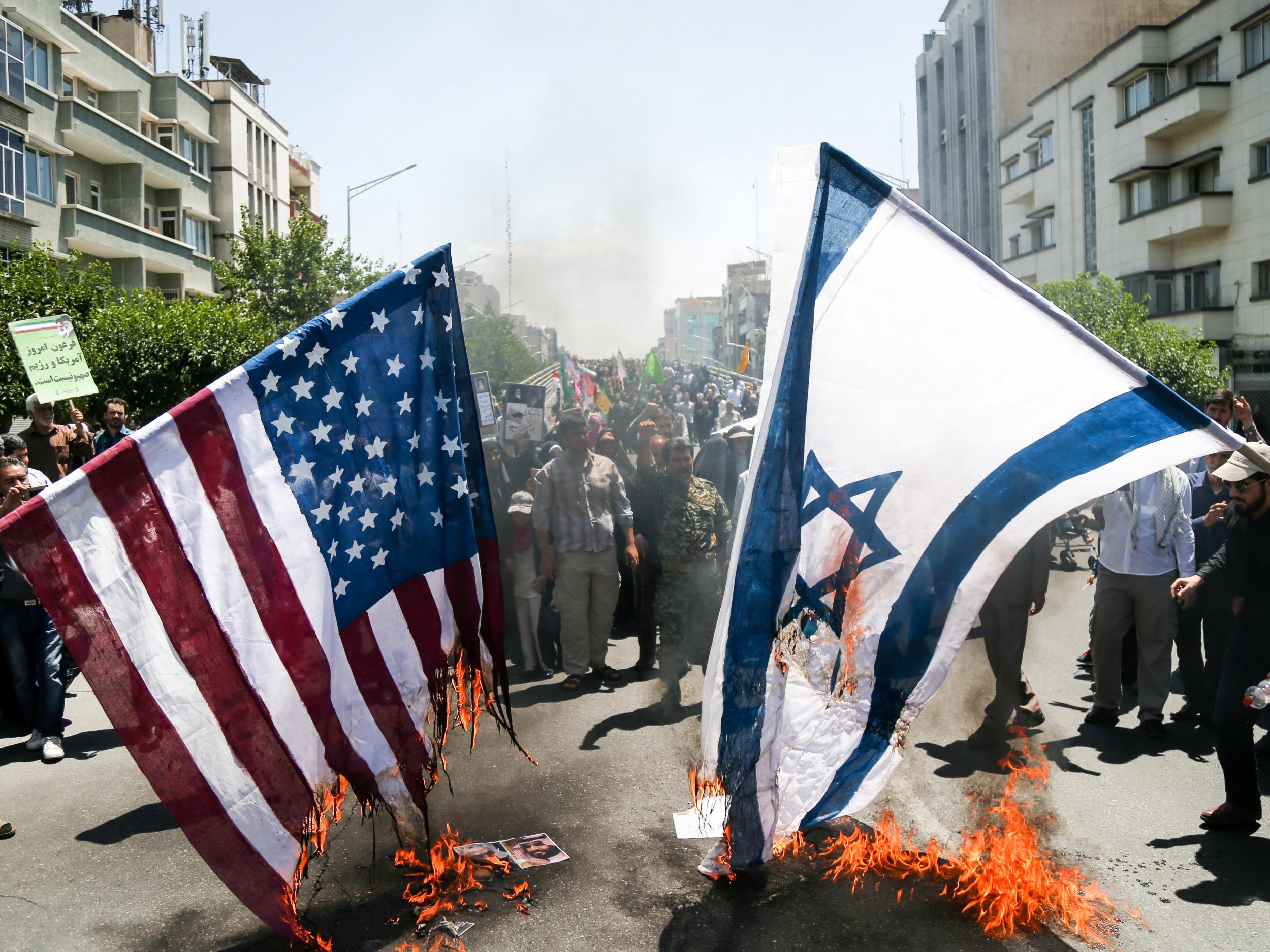 Iranians burn US and Israel flags during a protest marking the annual Quds Day on the last Friday of the holy month of Ramadan in Tehran, Iran