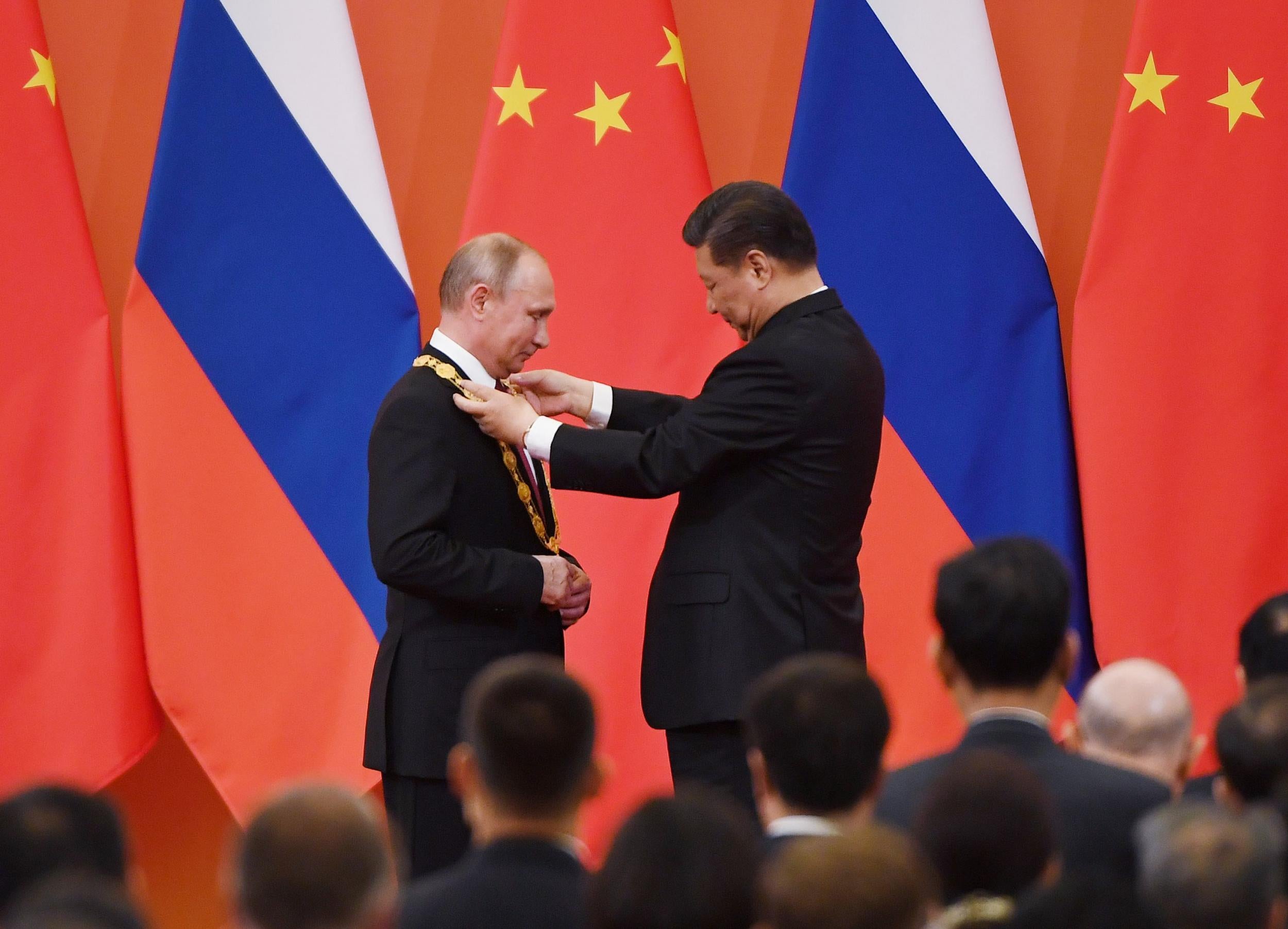 Chinese President Xi Jinping presents Russian President Vladimir Putin with the Medal of Friendship in the Great Hall of the People in Beijing