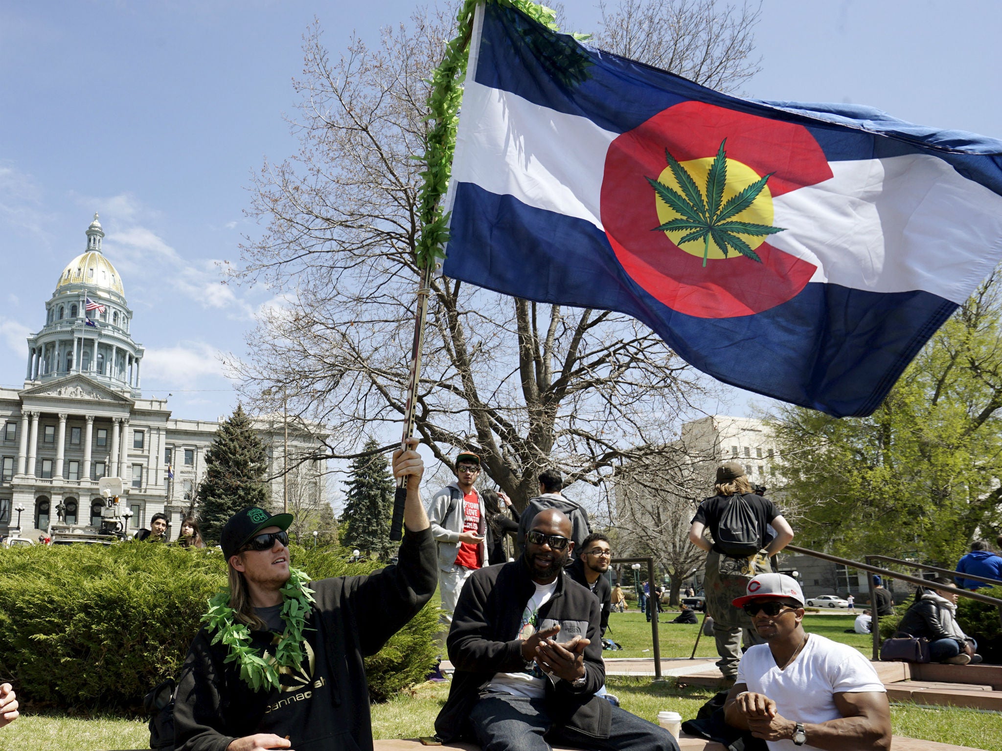 A man waves a Colorado flag with a marijuana leaf on it at Denver's annual 4/20 marijuana rally in front of the state capitol building