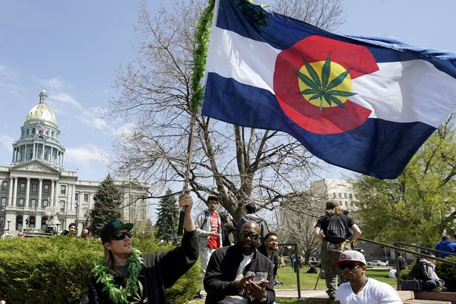 A man waves a Colorado flag with a marijuana leaf on it at Denver's annual 4/20 marijuana rally in front of the state capitol building