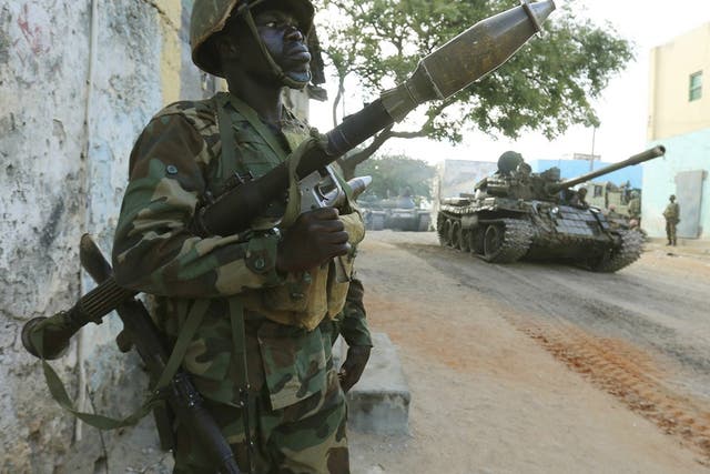 A Somali army soldier keeps guard as a tank rolls past after they captured the town of Barawe in 2014. The US military helps local forces to fight terror group al Shabaab