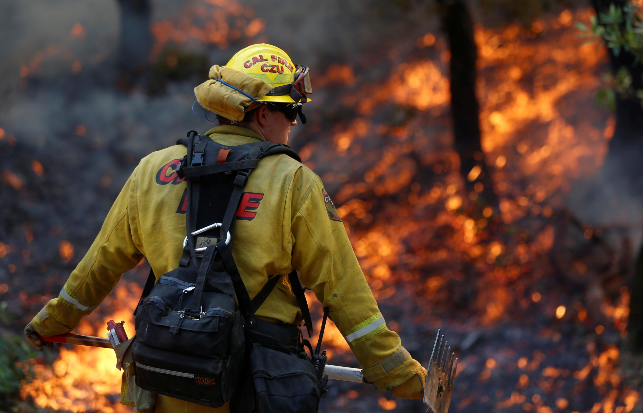 Firefighters work to defend homes from an approaching wildfire in Sonoma, California on 14 October 2017