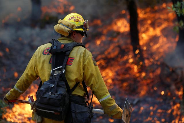 Firefighters work to defend homes from an approaching wildfire in Sonoma, California on 14 October 2017